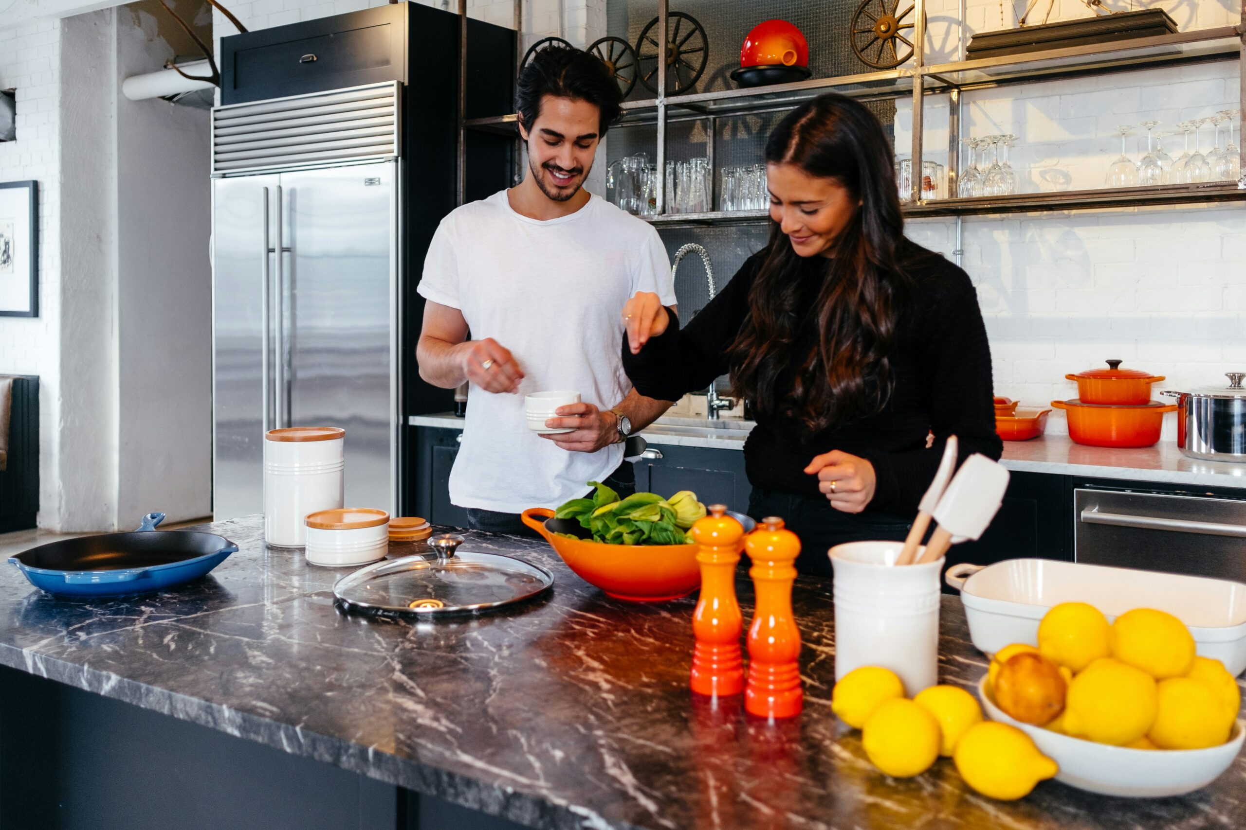 Bild von zwei Menschen in der Küche, die gemeinsam kochen.