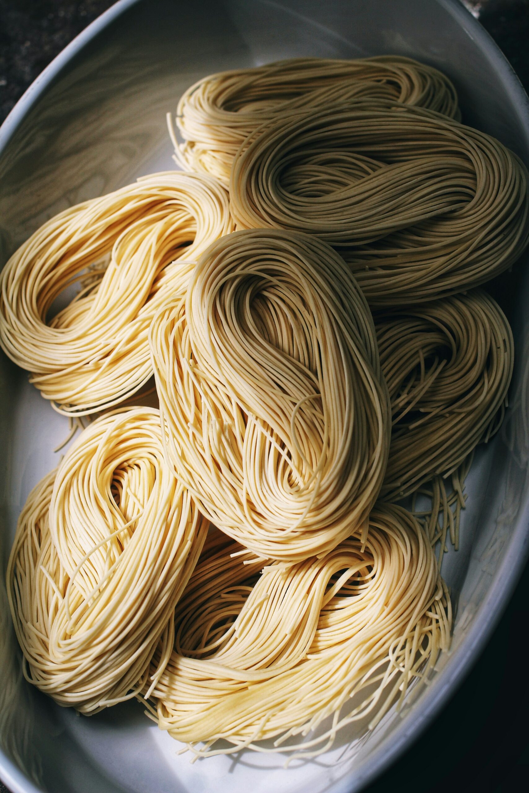 Tagliolini-Kunst: Frische Nudeln, Perfektioniert Bild von frisch zubereiteten Tagliolini-Nudeln auf einem Teller.